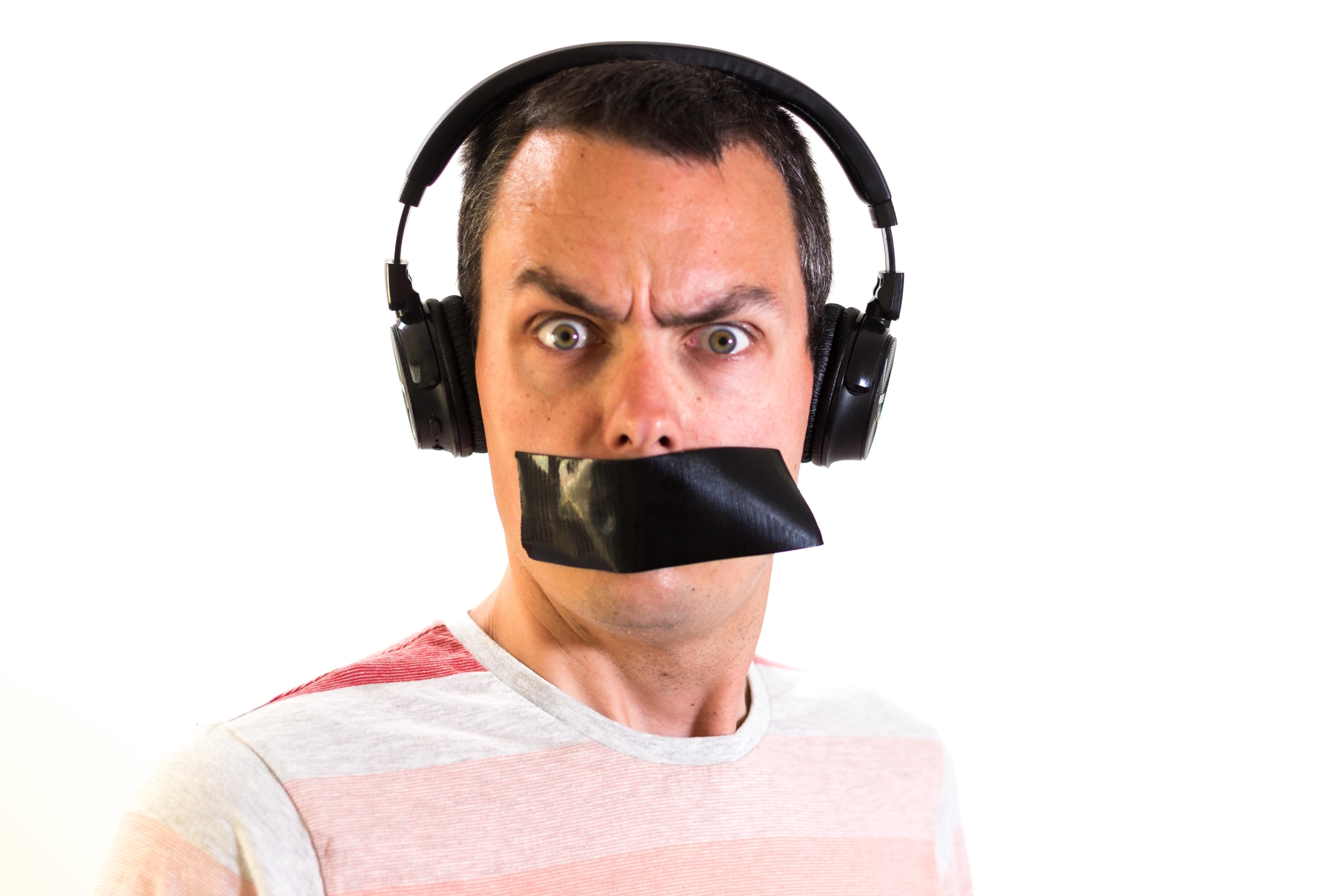 Marc Steele wearing headphones and looking startled, with some duct tape over his mouth